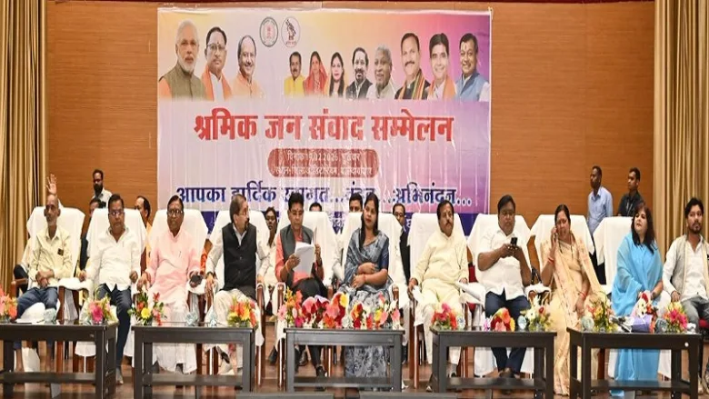 Revenue Minister Tank Ram Verma distributing checks to laborers in Baloda Bazar.