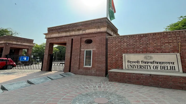 Delhi University North Campus entrance gate with students walking under clear daylight.