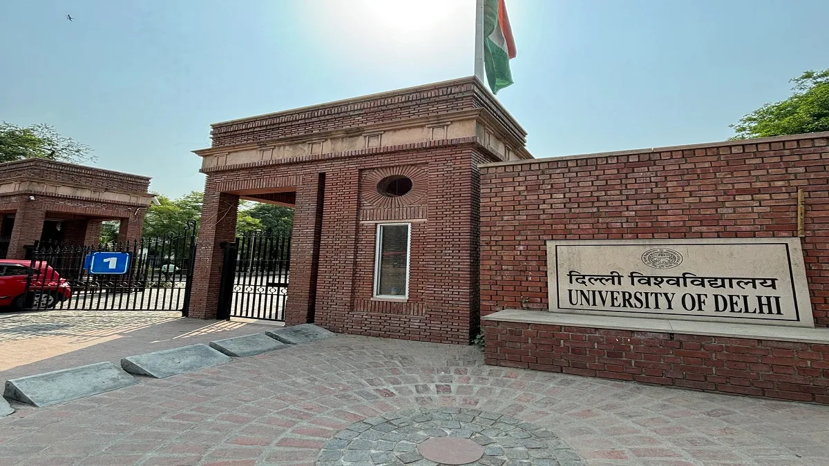 Delhi University North Campus entrance gate with students walking under clear daylight.