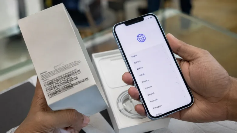 Representative image of a user holding a mobile phone while checking out a new smartphone.