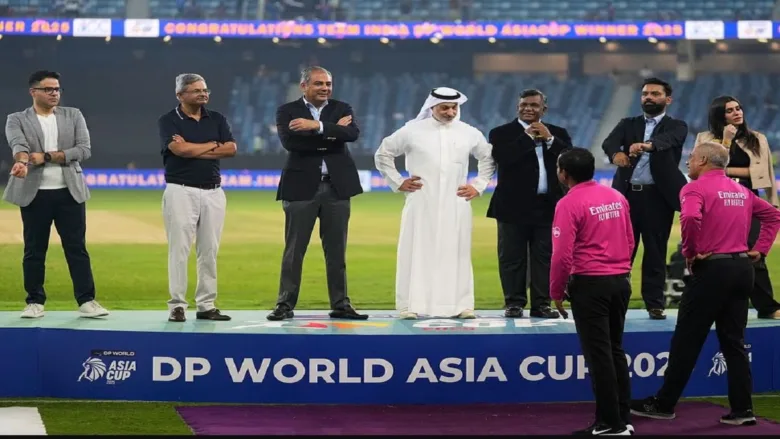 Mohsin Naqvi waits with the Asia Cup trophy during the post-match presentation after India's women's Asia Cup final victory.